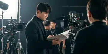K-drama actor reviewing script on set, busy filming day